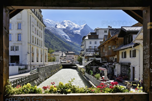 Glacier river Arve flows through the city, with the snow-capped Mont-Blanc mountain range behind, Chamonix-Mont-Blanc, Haute-Savoie, France