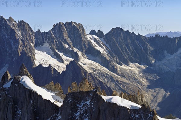 Rugged rocks jut out of a snow-covered mountain, viewing platform, Aiguille du Midi mountain station, Chamonix-Mont-Blanc, Haute-Savoie, France