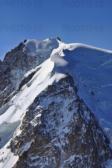 A group of mountaineers runs across a snow-covered mountain, Aiguille du Midi, Chamonix-Mont-Blanc, Haute-Savoie, France