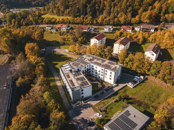 Aerial view of an autumnal residential area with solar panels and surrounding trees, Nagold, Black Forest, Germany