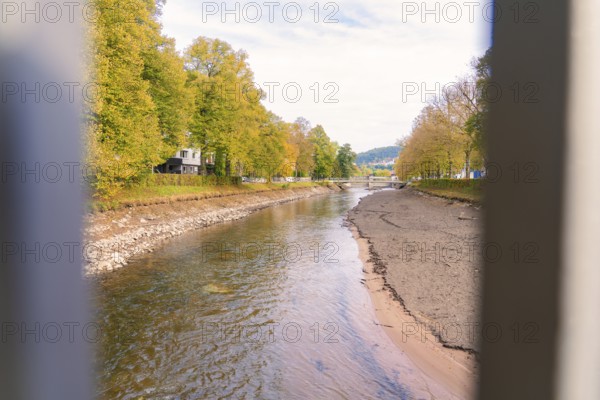 River landscape in autumn with trees and calm water surface, Nagold, Black Forest, Germany