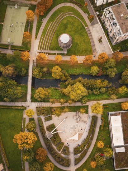 Viaduct leads through an urban area with houses and autumn trees, near a skate park, Nagold, Black Forest, Germany