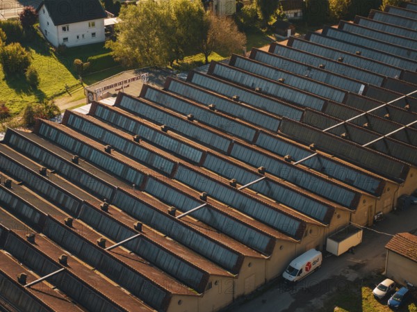 Industrial roof structure with a delivery vehicle in an autumn light, seen from the air, Nagold, Black Forest, Germany