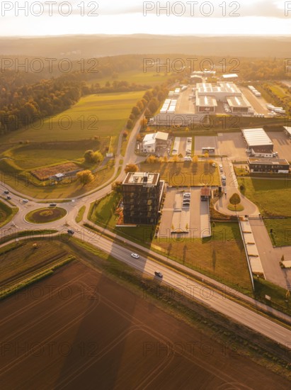 Tour of houses and commercial buildings surrounded by fields, in the golden light of the evening sun, Nagold, Black Forest, Germany