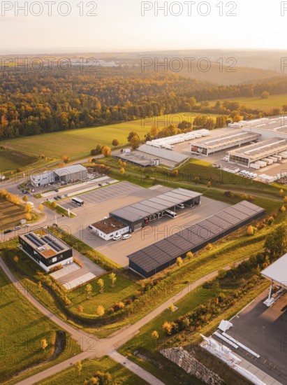 Industrial area from above, surrounded by fields and forests, under a warm evening sky, Nagold, Black Forest, Germany