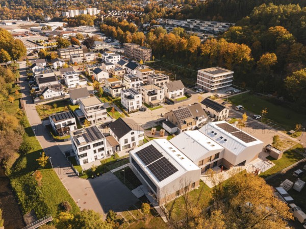 A residential area with modern houses and solar panels, surrounded by autumn trees, Nagold, Black Forest, Germany