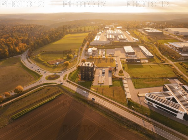 Overview of a large industrial area in the evening light, surrounded by fields and hills, Nagold, Black Forest, Germany