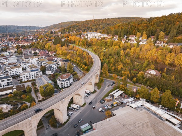 Aerial view of a city with a bridge across a valley and autumn trees along the hills, Nagold, Black Forest, Germany