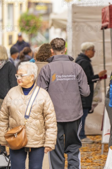 People in jackets stroll at a market surrounded by stalls and fallen leaves, traditional fruit market, Sindelfingen, Böblingen district, Germany