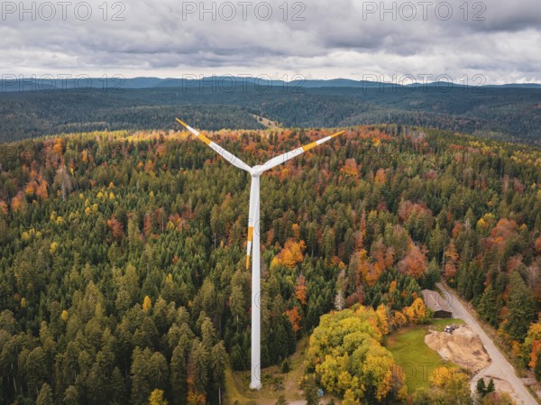 Wind turbines in autumn forest surrounded by clouds and roads, Simmersfeld wind farm, Germany