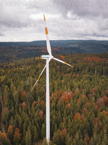 Wind turbine over autumn tree landscape under cloudy sky, Simmersfeld wind farm, Germany
