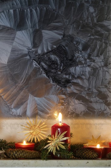 Christmassy decorated iced window, candle light, straw stars, Germany