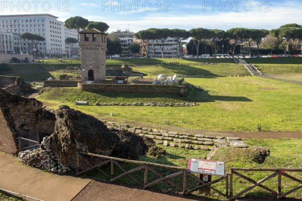 View of location from in the foreground ruins of former stands around south bend of on Circus Maximus venue of chariot races, in the middle medieval tower Torre della Moletta, part of medieval building ruin from the Middle Ages in the archaeological complex of Circus Maximus, Rome, Lazio, Italy