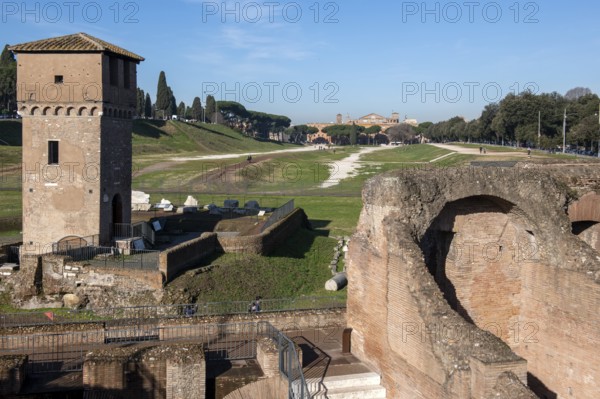 View of location from in the foreground ruins of former stands around south bend of on Circus Maximus venue of chariot races, left medieval tower Torre della Moletta, part of medieval building ruin from the Middle Ages in the archaeological complex of Circus Maximus, Rome, Lazio, Italy