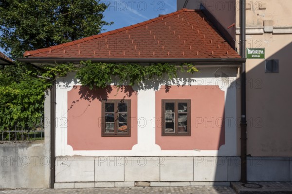 Pink house facade, window with old objects, Kranj, Upper Carniola, Slovenia