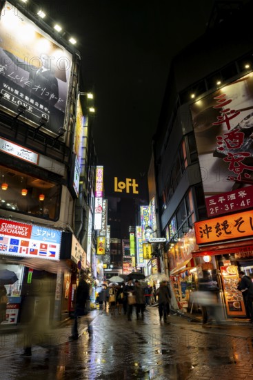 Busy pedestrian zone with many shopping centers and stores, illuminated with lots of neon signs at night, Shibuya, Udagawacho, Tokyo, Japan