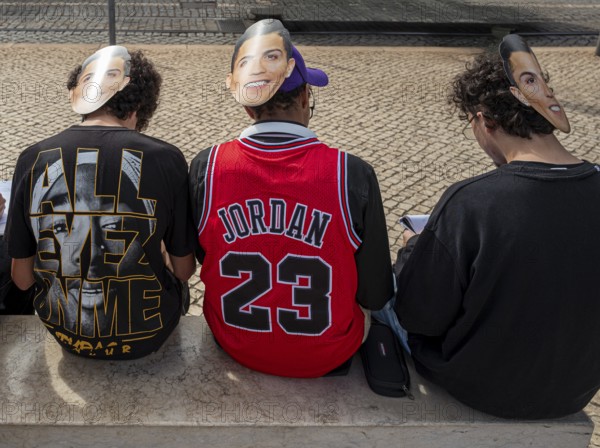 Street art, young people with Ronaldo mask on the back of their heads taking part in a school project about drawing, Lisbon, Portugal