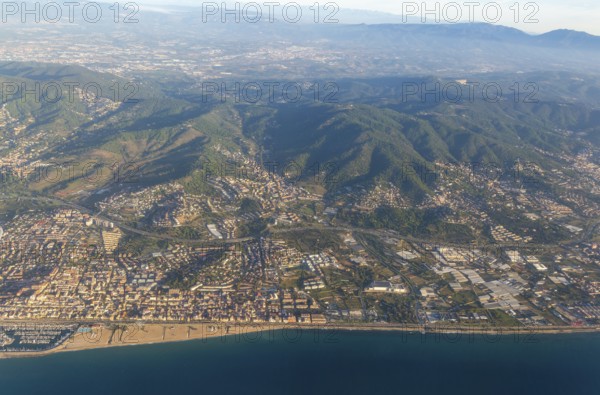 Oblique aerial view of settlements on coastal plain and hillsides, Mediterranean Sea coast, El Masnou, Barcelona, Catalonia, Spain