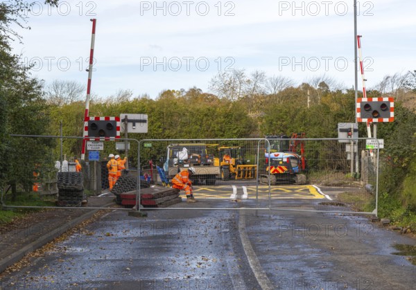 Road and rail level crossing closed, Network Rail railway line upgrade maintenance, Melton, Suffolk, England, UK autumn 2025