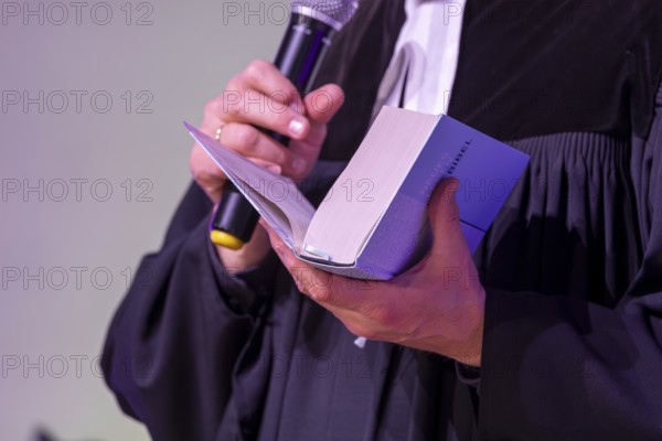 Protestant priest holding a Bible (church symbol)