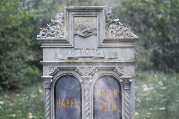 Tombstone at a cemetery with (added) text HAPPY HALLOWEEN (digitally reworked)
