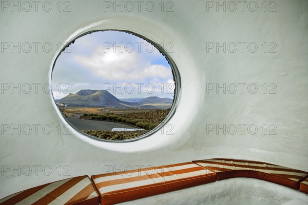 Round porthole style window in building designed by Cesar Manrique with the collaboration of Jesús Soto and architect Eduardo Caceres, without right angles corners on viewpoint tourist attraction El Mirador del Río on the summit of the 474 meter high Risco de Famara in the Famaramassiv with panoramic view of the Chinijo archipelago, extinct volcano, Lanzarote, Canary Islands, Canary Islands, Spain