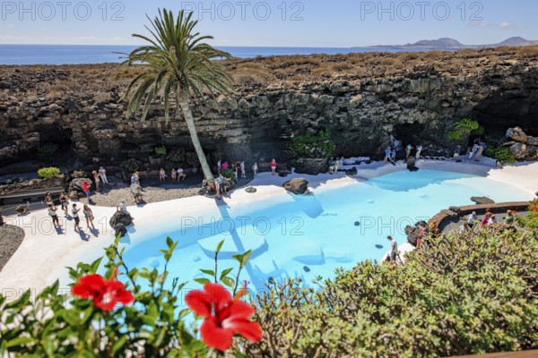 View from elevated position of pool designed by César Manrique Swimming pool in art venue cultural center tourist attraction Jameos del Agua, Punta Mujeres, Lanzarote, in the background East Atlantic, Canary Islands, Spain