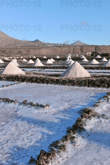Small conical mounds of sea salt in historic saline for salt production Las Salinas de Janubio, Yaiza, Lanzarote, Canary Islands, Spain