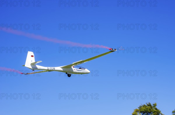 An SZD-59-1 ACRO glider, registration D-1138, during a demonstration as part of an air show at the Fliegerbergfest of the Rossfeld Luftsportverein in Metzingen-Glems, Baden-Württemberg, Germany, for editorial use only