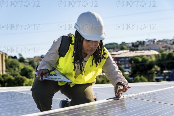 Woman engineer installing or maintaining solar panels on a rooftop, symbolizing renewable energy, sustainability, and technological progress in the green economy