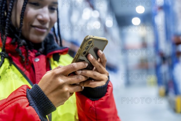 Logistics professional checking inventory with a mobile phone, optimizing cold chain operations and managing supply in a modern frozen warehouse environment