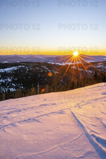 Sunrise over the hills of czech republic from Mount Lusen wth the view over the hills of the bavarian forest in winter, Bavaria, Germany