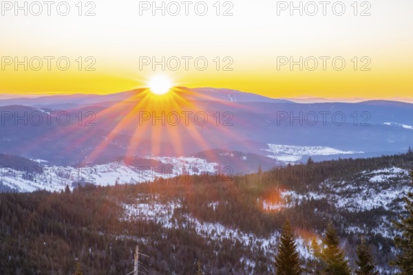 Sunrise over the hills of czech republic from Mount Lusen wth the view over the hills of the bavarian forest in winter, Bavaria, Germany