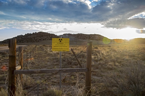 Jeffrey City, Wyoming - The sun rises behind a 'No Trespassing' signs which adorns the perimeter of a former uranium mine and mill which operated from 1957 until 1981. Uranium tailings and other radioactive debris have been buried and the site is now under the care of the Department of Energy