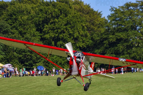 A Piper J-3C/L4 Cub light aircraft, HB-OBF registration, during a flight demonstration as part of an air show on Rossfeld in Metzingen-Glems, Baden-Württemberg, Germany, for editorial use only