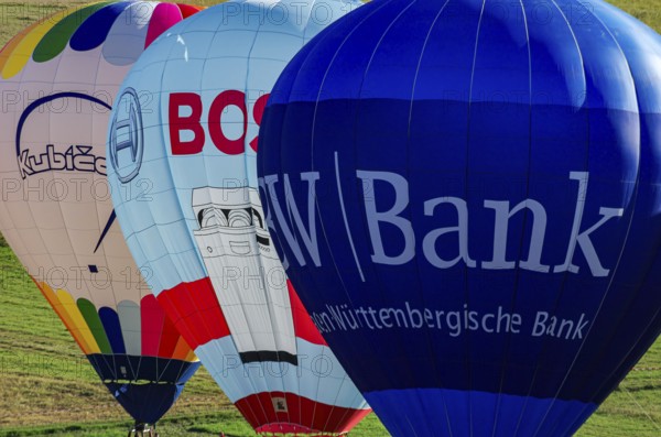 Hot air balloons are being prepared for takeoff as part of an air show at the Fliegerbergfest of the Rossfeld Luftsportverein in Metzingen-Glems, Baden-Württemberg, Germany, for editorial use only