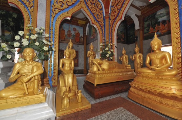 Prayer room devotional room with golden statues from left Monk and Buddha in the temple complex Wat Chalong Pilgrimage Site, Wat Chaithararam, Phuket Province, Phuket Island, Thailand