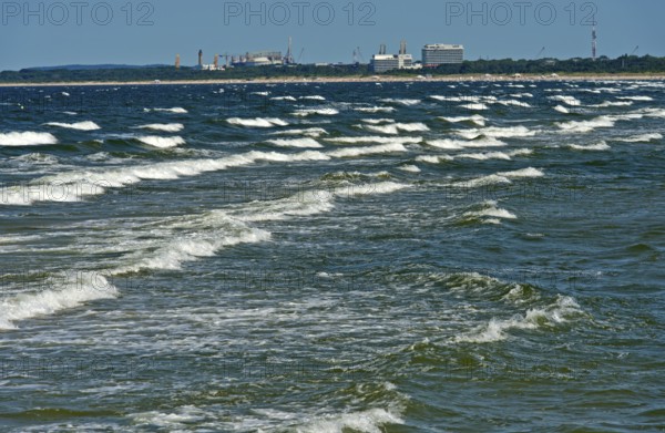 Baltic Sea waves, waves wash on the beach at the seaside resort of Ahlbeck, behind the skyline of Swinoujscie, Swinoujscie, Usedom island, Mecklenburg-Western Pomerania, Germany