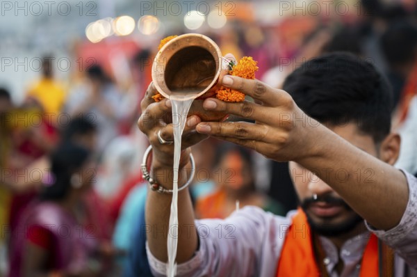 A Hindu devotee offer prayers to the Sun God on the bank of Brahmaputra river on the occasion of Chhath Puja, in Guwahati, India on 27 October 2025