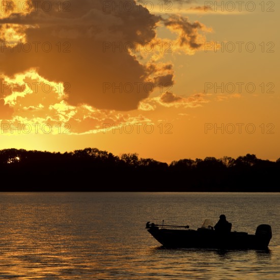 A boat on Lake Gudelack at sunset, Lindow (Mark), Stechlin-Ruppiner Land nature park Park, Brandenburg, Germany