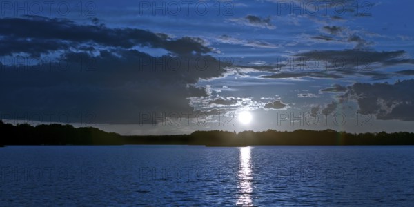 Atmospheric moonrise over Lake Gudelack, Lindow (Mark), Stechlin-Ruppiner Land nature park Park, Brandenburg, Germany
