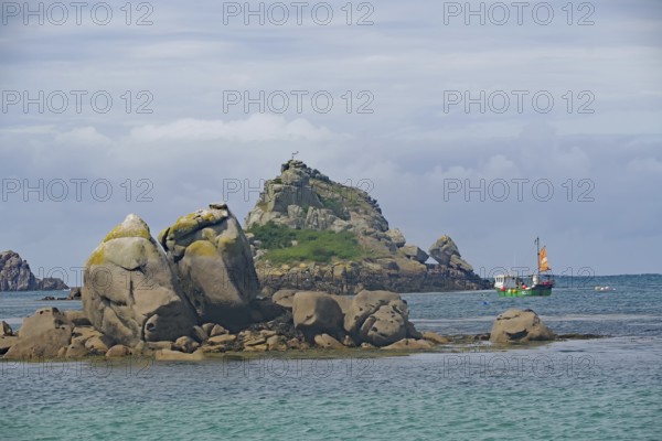 Rocks and small island in the sea accompanied by boats and slightly cloudy sky, Isles of Scilly, Cornwall, Great Britain