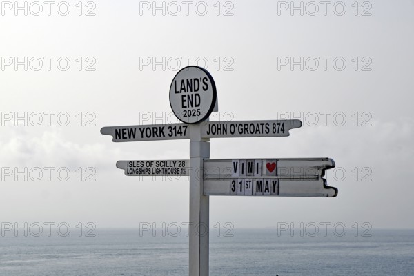 Guide to a coastal town with various city names and distances, New York, Land's End, Cornwall, Great Britain