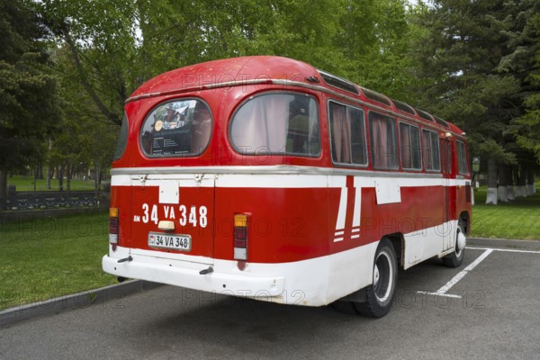 Back view of a red vintage bus in a parking lot with trees in the background, PAZ-672, minibus of the Soviet manufacturer Pavlovsky, Jermuk, Jermuk, Vayots Dzor Province, Armenia