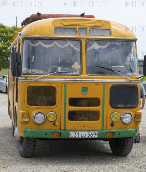 An old orange bus with retro design parked on a street, PAZ-672, minibus from Soviet manufacturer Pavlovsky, gas drive, Khor Virap, Ararat province, Armenia