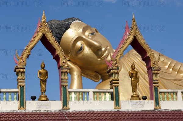 Head of reclining Buddha resting head on hand forearm on elbow, landmark of Wat Sri Sunthon Buddhist monastery, Phuket island, Phuket province, Thailand