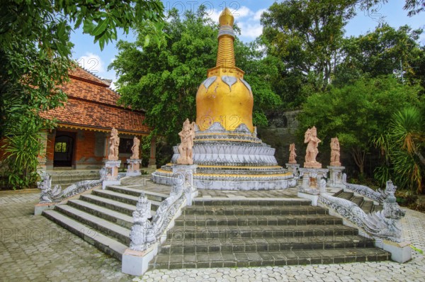 Large golden golden stupa on pedestal with steps, in front of guardian figures Buddhist monastery Brahma Vihara Brahmavihara Arama, Banjar, Bali, Indonesia