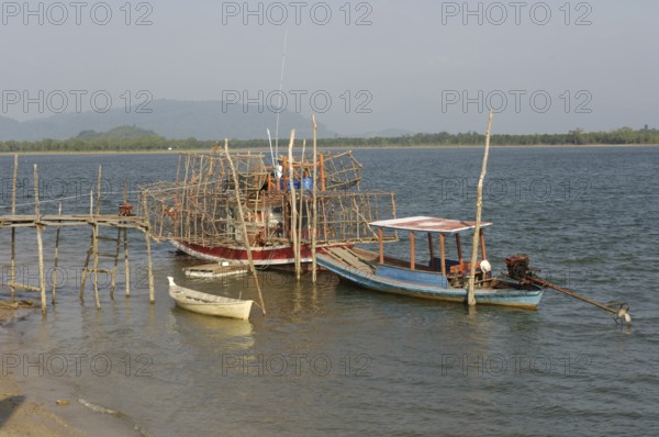 Small fishing boat on the right, boat on it lots of large bamboo traps, Phang Nga Phang-nga province, Thailand