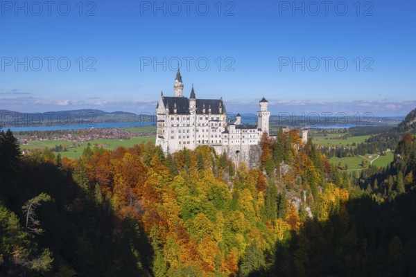 The fairytale Neuschwanstein Castle with autumn trees and views of the surrounding countryside, Schwangau, Königswinkel, Ostallgäu, Allgäu, Swabia, Bavaria, Germany
