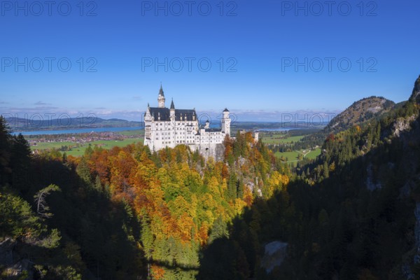 The impressive Neuschwanstein Castle surrounded by colorful autumn trees and a vast landscape, Schwangau, Königswinkel, Ostallgäu, Allgäu, Swabia, Bavaria, Germany